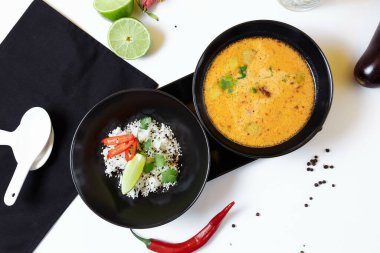 Tom Kha. Baharatlı Asya çorbası, patlıcan, tavuk, mantar, limon otu, pirinç ve kişniş ile servis edilir..