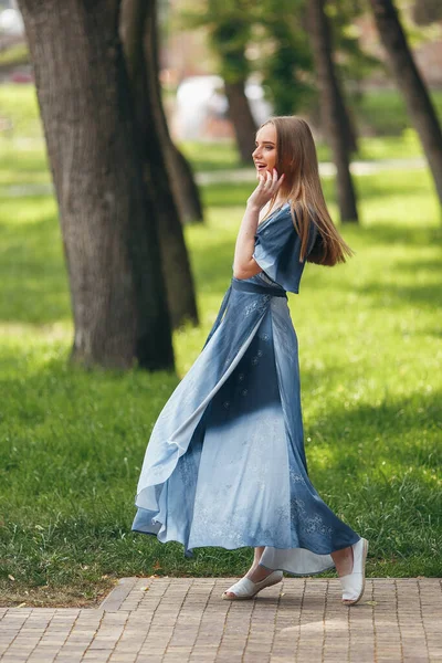 Stilvolles Mädchen posiert in einem Kleid in einem sonnigen Frühlingspark. Fröhliches, glückliches Porträt eines schönen Mädchens im Sommer — Stockfoto