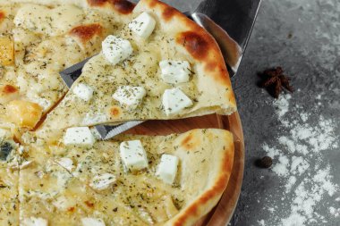 Dört peynirli pizza, İtalyan pizzası. Gri arka planda dört çeşit peynirle doldurulmuş pizza.
