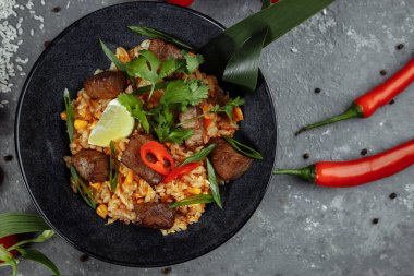 Gri desenli arka planda sığır eti ve sebzeli kızarmış pirinç..