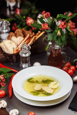 Lezzetli tavuk çorbası dolu beyaz bir kase..