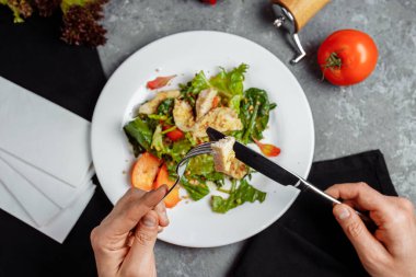 Sezar salatası ve tavuk yiyen adam. Yukarıdan Fotoğraf.