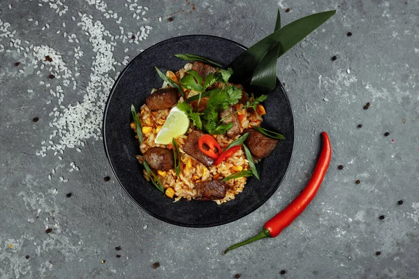 Gri desenli arka planda sığır eti ve sebzeli kızarmış pirinç..