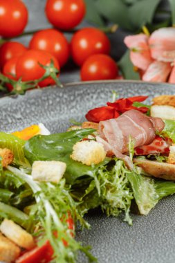 Dekorlu ve kopyalanmış gri tabakta sezar salatası.
