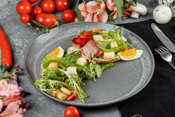 caesar salad on a gray plate with decor and copyspace.