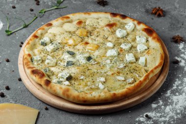 Dört peynirli pizza, İtalyan pizzası. Gri arka planda dört çeşit peynirle doldurulmuş pizza.