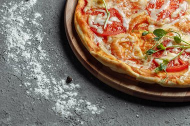 Siyah taş arka planda Pizza Margherita, en iyi manzara. Domates, fesleğen ve Mozzarella peynirli pizza..