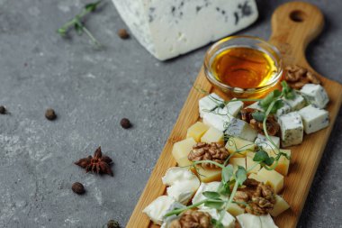 Peynir tabağına yakın çekim. 4 çeşit peynir, yumuşak beyaz peynir, camembert peyniri, yarı yumuşak briç, mavi, rokfor, sert peynir. Ceviz, yeşil üzüm. Güzel servis. restoran.