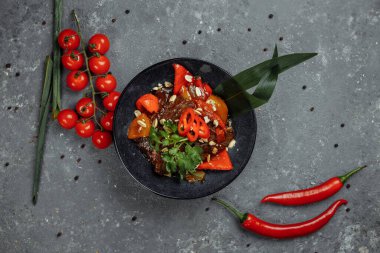 Biftek lokantası. Geleneksel Çin sığır eti kızartması Çin yapımı dökme demir tavada, yemek çubuklarıyla, taş kaplama arka planda. Üst görünüm, alanı kopyala