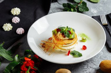 Gri mavi tabakta kremalı börek yığını..