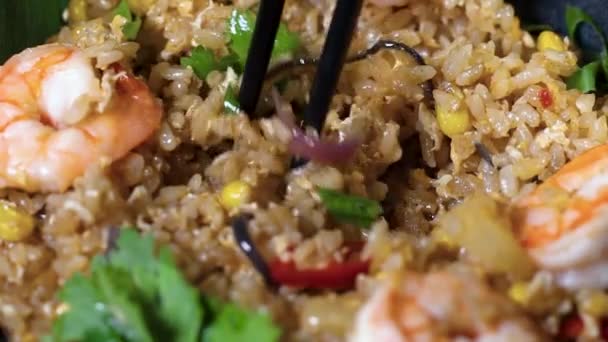 Thailändskt ris med räkor i en svart platta på en mörk bakgrund. upphovsrättsplats — Stockvideo