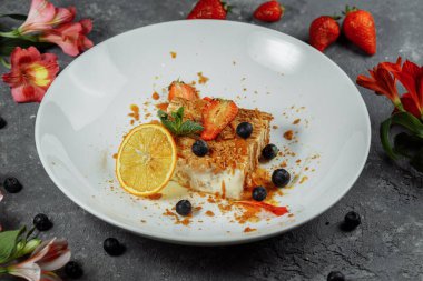 Karamel soslu Napolyon keki. Çilek, yaban mersini ve naneyle süslenmiş muhallebi ve karamel soslu lezzetli börek..