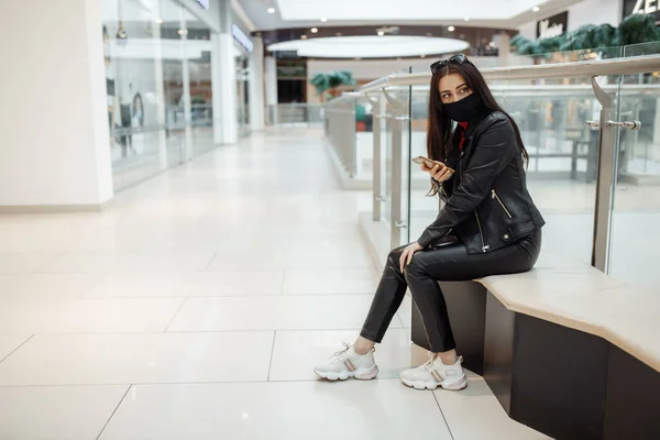 Flicka Med Medicinsk Svart Mask Och Mobiltelefon Ett Köpcentrum Coronavirus — Stockfoto