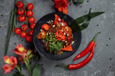 Biftek lokantası. Geleneksel Çin sığır eti kızartması Çin yapımı dökme demir tavada, yemek çubuklarıyla, taş kaplama arka planda. Üst görünüm, alanı kopyala.