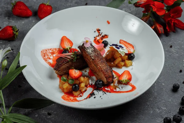 Duck breast with strawberry sauce.bon appetit. fine dining.Duck breast, strawberry sauce, apple salsa with cinnamon, seasonal berries. top food background. copy space