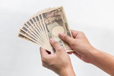 Beyaz arka plan, Japon yeni mali ve iş kavramı üzerinde izole işkadını vererek para ve 10.000 Japon yen para elinde tutan