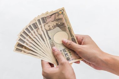 Beyaz arka plan, Japon yeni mali ve iş kavramı üzerinde izole işkadını vererek para ve 10.000 Japon yen para elinde tutan