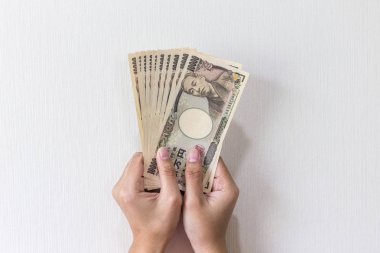 Beyaz arka plan, Japon yeni mali ve iş kavramı üzerinde izole işkadını vererek para ve 10.000 Japon yen para elinde tutan