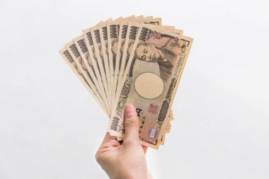 Beyaz arka plan, Japon yeni mali ve iş kavramı üzerinde izole işkadını vererek para ve 10.000 Japon yen para elinde tutan