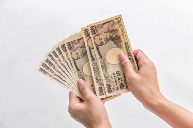 Beyaz arka plan, Japon yeni mali ve iş kavramı üzerinde izole işkadını vererek para ve 10.000 Japon yen para elinde tutan