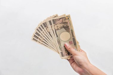 Beyaz arka plan, Japon yeni mali ve iş kavramı üzerinde izole işkadını vererek para ve 10.000 Japon yen para elinde tutan
