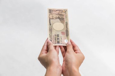 Beyaz arka plan, Japon yeni mali ve iş kavramı üzerinde izole işkadını vererek para ve 10.000 Japon yen para elinde tutan
