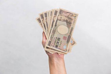 Beyaz arka plan, Japon yeni mali ve iş kavramı üzerinde izole işkadını vererek para ve 10.000 Japon yen para elinde tutan