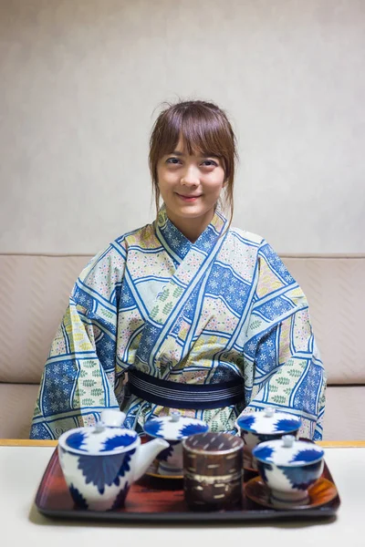 Woman wearing traditional japanese yukata or kimono make a tea in japan style.