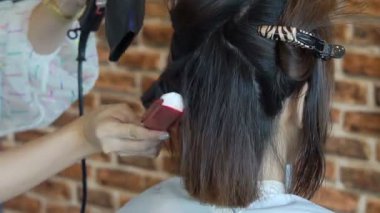 Kadının saçını alma ve saç kurutma makinesi ve yuvarlak fırça ile sarışın saç kurutma Kuaför Salonu yakın çekim.