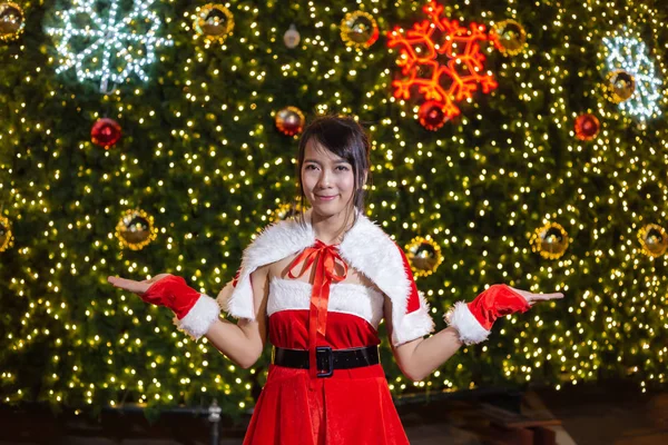幸せな笑みを浮かべてサンタ少女はクリスマスと幸せな新年の祭りのクリスマス ツリー背景お祝いと赤いスーツでかわいい — ストック写真