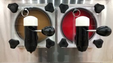 Mağazada bir konteyner gümüş makine içinde renkli buz suyu dönen ve etrafında dönüyor