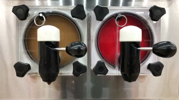 Jugo de hielo colorido dentro de una máquina de plata contenedor en la tienda girando y girando — Vídeos de Stock