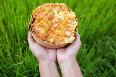 Yasemin pirinç arka plan ile elde geleneksel bambu örgü plakaları üzerinde omlet sosis ile Pirinç.