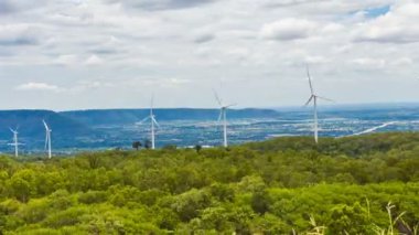 Doğanın ortasında Rüzgar enerjisi türbinleri, geçit ve ağaçlar gökyüzü arka plan, Enerji jeneratör doğa dostu. Bahar tarlası. Zaman atlamalı