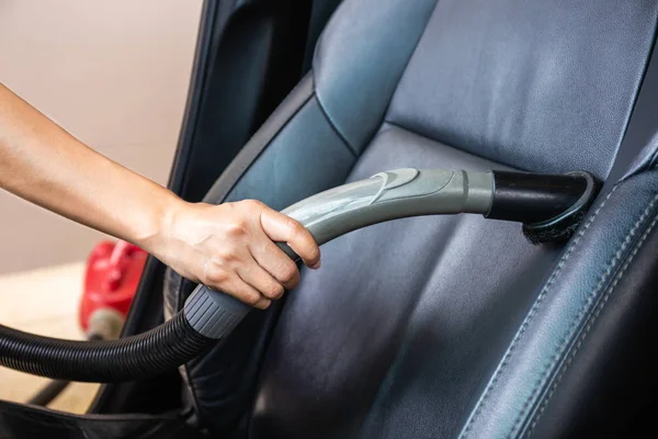 Cleaning modern car interior with vacuum cleaner. Handle vacuum