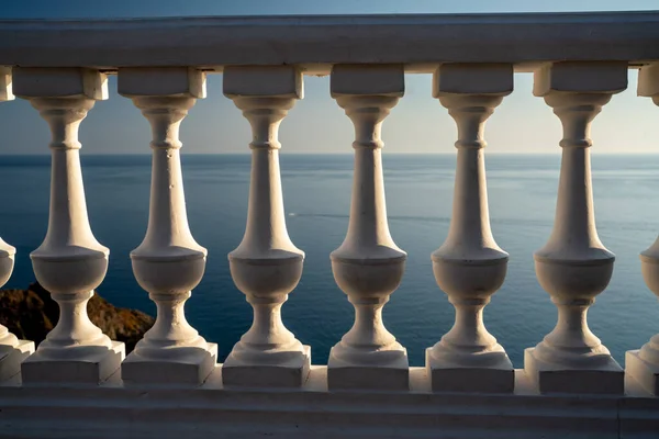 Classica balaustra sul terrapieno contro il mare. Balcone bianco sul mare. Passeggiata con una splendida vista sul mare in una giornata limpida. Primo piano della balaustra in riva al mare — Foto Stock