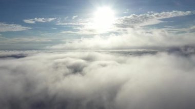 Güneşle birlikte bulutların üzerinde uçan hava manzarası.