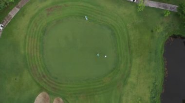 Sabah hava manzaralı yeşil golf sahası ve sis.