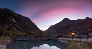 Dağlarda gün batımı Alplerdeki gölde yansıyor.