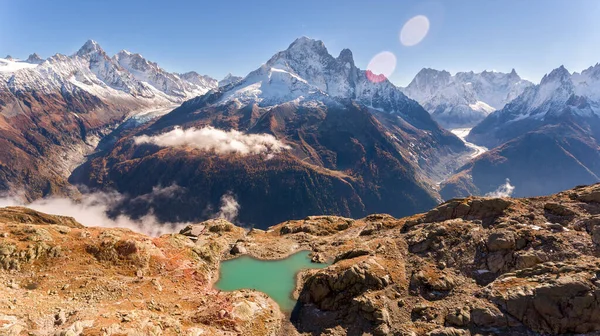 Landscape view of huge mountain range with mountains covered in snow and small lake in the Alps