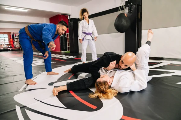 Dört Judo dövüş sanatları partnerinden oluşan bir grup ve spor paspasında yeni teknikler geliştiren bir eğitmen.