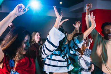 Neşeli genç arkadaşlar canlı bir gece kulübünde dans edip kutlama yapıyorlar. Canlı bir müzik konserinin heyecan verici atmosferinin tadını çıkarıyorlar.