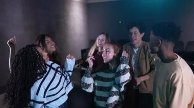 Genç arkadaşlar loş barın içinde enerjik bir şekilde dans ediyor, senkronize ağır çekim hareketleriyle coşkulu bir neşe anı paylaşıyorlar, kaygısız Z kuşağı ruhunu ifade ediyorlar.