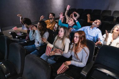 İnsanlar sinemada film izlerken korku ve şaşkınlıkla tepki veriyor. Gergin bir sahnede hayal kırıklığı yaşıyorlar.