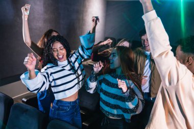 Heyecanlı hayranlar dans ediyor ve en sevdikleri gruba eşlik ederek canlı ve enerjik bir atmosfer yaratıyorlar.