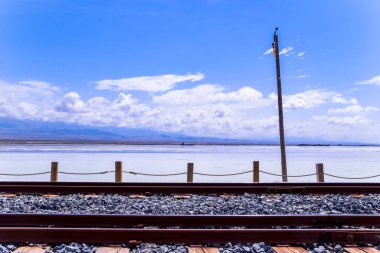 Freight train track go through Chaka Salt Lake,Qinghai province,China. clipart