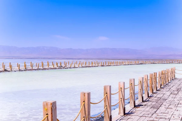 Engin tuz gölünün üzerinde uzun ahşap kaldırımlar var. Chaka Tuz Gölü 'nün güzel manzarası Çin' in Qinghai eyaletinde yaz mevsimindedir..