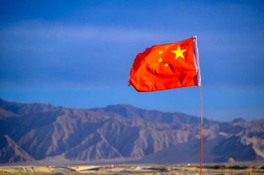 Çin Bayrağı, Çin 'in Qinghai eyaletindeki Dachaidan Zümrüt Tuz Gölü' nde rüzgarda dalgalanıyor.