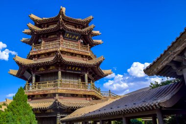 Mingyue Pavyonu Crescent Lake Oasis 'in içinde ve çöl arka planında. Burası Çin 'in Dunhuang şehrinde ipek yolunun ünlü bir yeri..