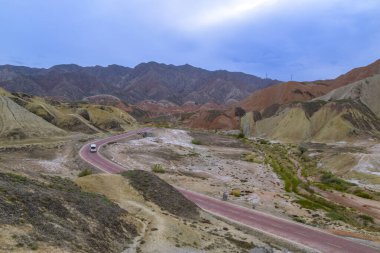 Gökkuşağı Dağı 'nın muhteşem manzarası ve gün batımında mavi gökyüzü arkaplanı. Zhangye Danxia National Geopark, Gansu, Çin. Renkli manzara, gökkuşağı tepeleri, sıra dışı renkli kayalar, kumtaşı erozyonu.